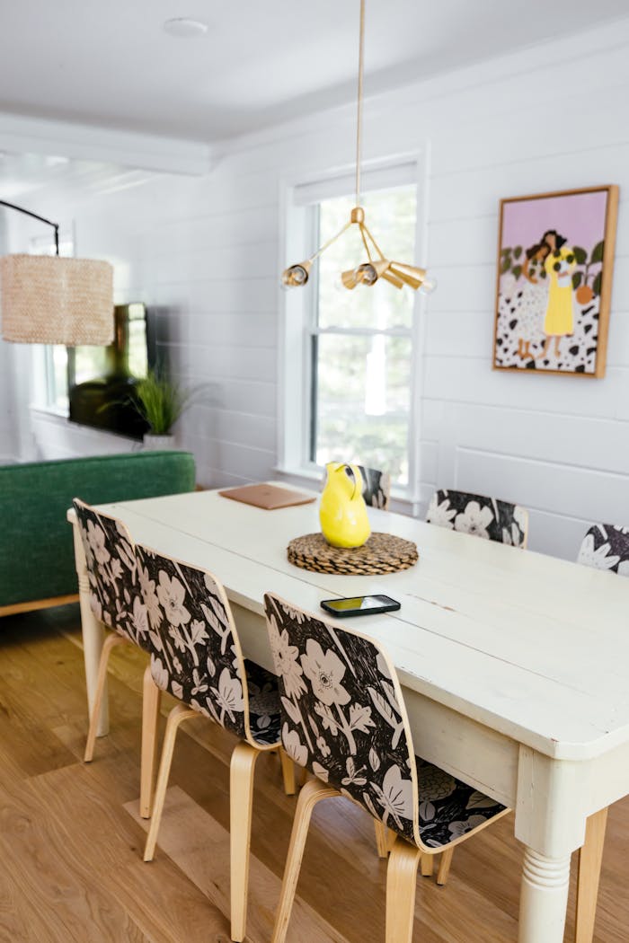 Offerings Contemporary dining room with floral chair design, vibrant decor, and modern artwork.