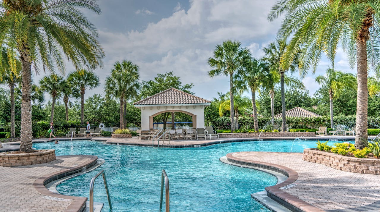 Offerings Relaxing tropical poolside scene with palm trees, gazebo, and clear blue water at a luxury resort.